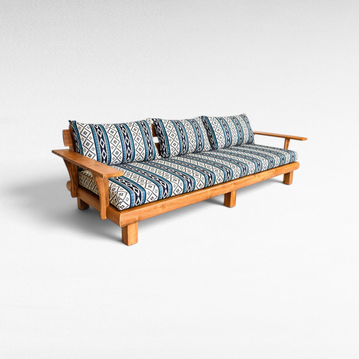 Chora Barefoot Luxury Living teak wood sofa with blue and white geometric patterned cushions on a white background