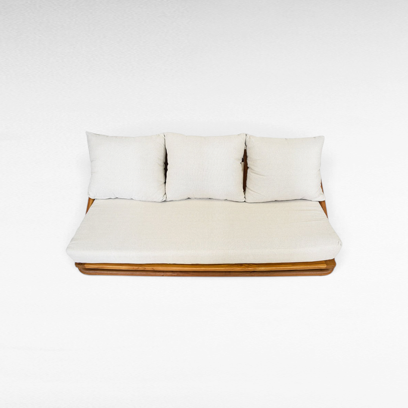 Chora Barefoot Luxury Living teak wood sofa with cream cushions and a warm honey-toned solid wood frame.