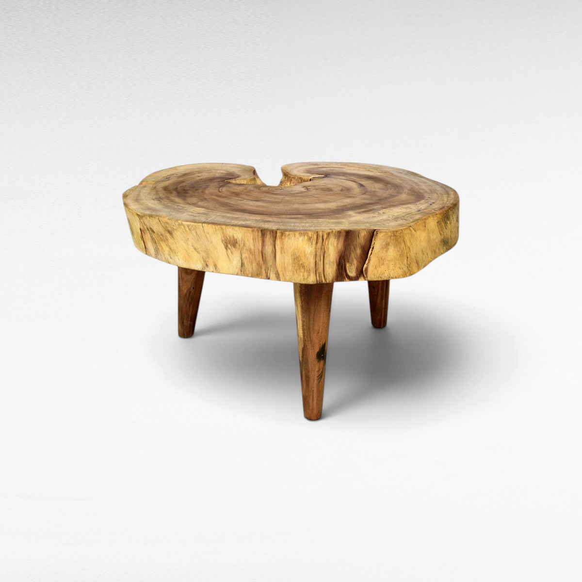 Chora Barefoot Luxury Living suar wood coffee table with a natural live edge round top and three sturdy wooden legs.