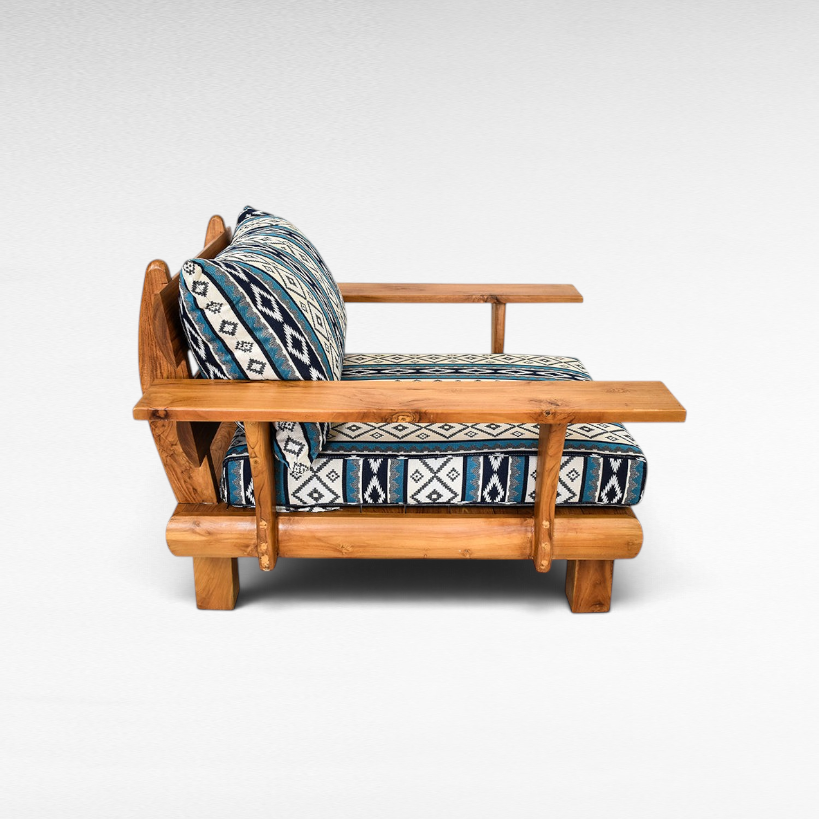 Chora Barefoot Luxury Living teak wood sofa chair with blue and white geometric patterned cushions, side view