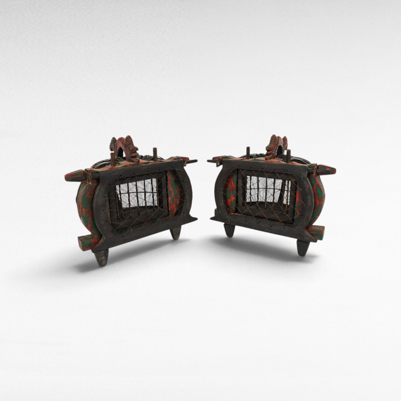 Pair of antique Chora Barefoot Luxury Living bird cages with distressed red and black wooden frames and wire mesh.