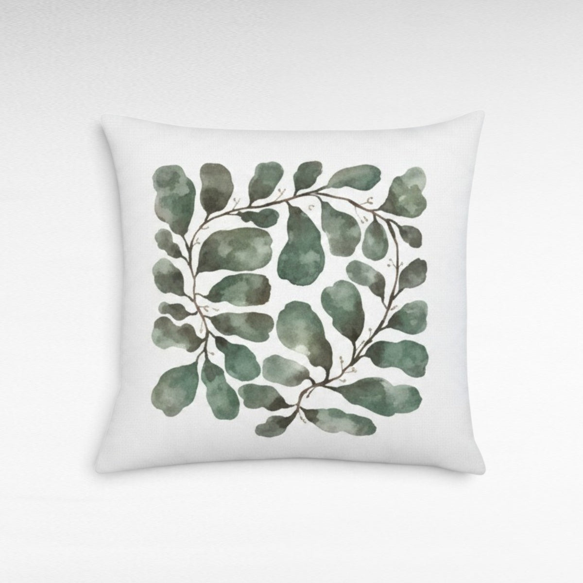 Chora Barefoot Luxury Living square throw pillow featuring a watercolor green leaf garland print on white fabric.