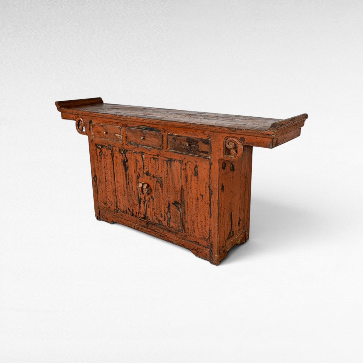 Chora Barefoot Luxury Living distressed orange wooden buffet with three drawers and a cabinet with ornate hardware.