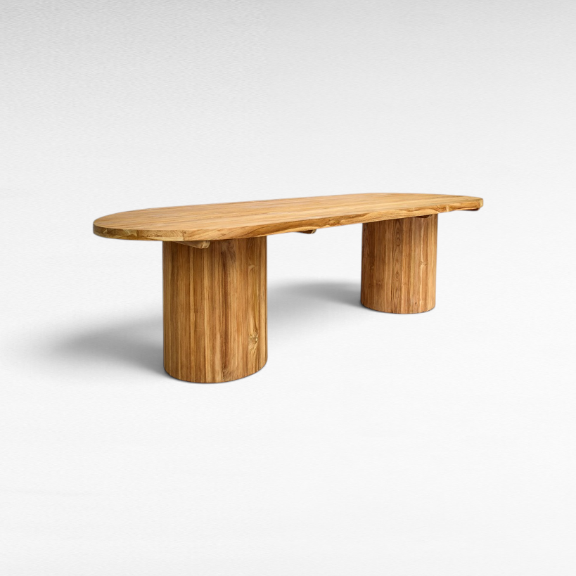 Chora Barefoot Luxury Living oval suar wood dining table with sculptural cylindrical bases and natural grain patterns.
