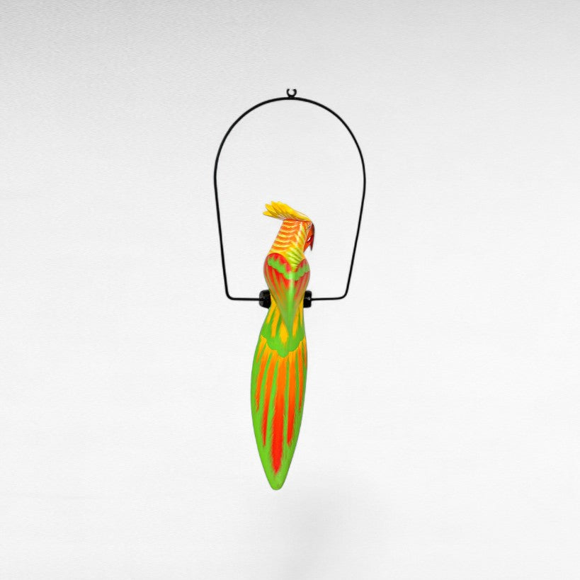 Chora Barefoot Luxury Living colorful wooden parrot decoration hanging from a black metal stand.