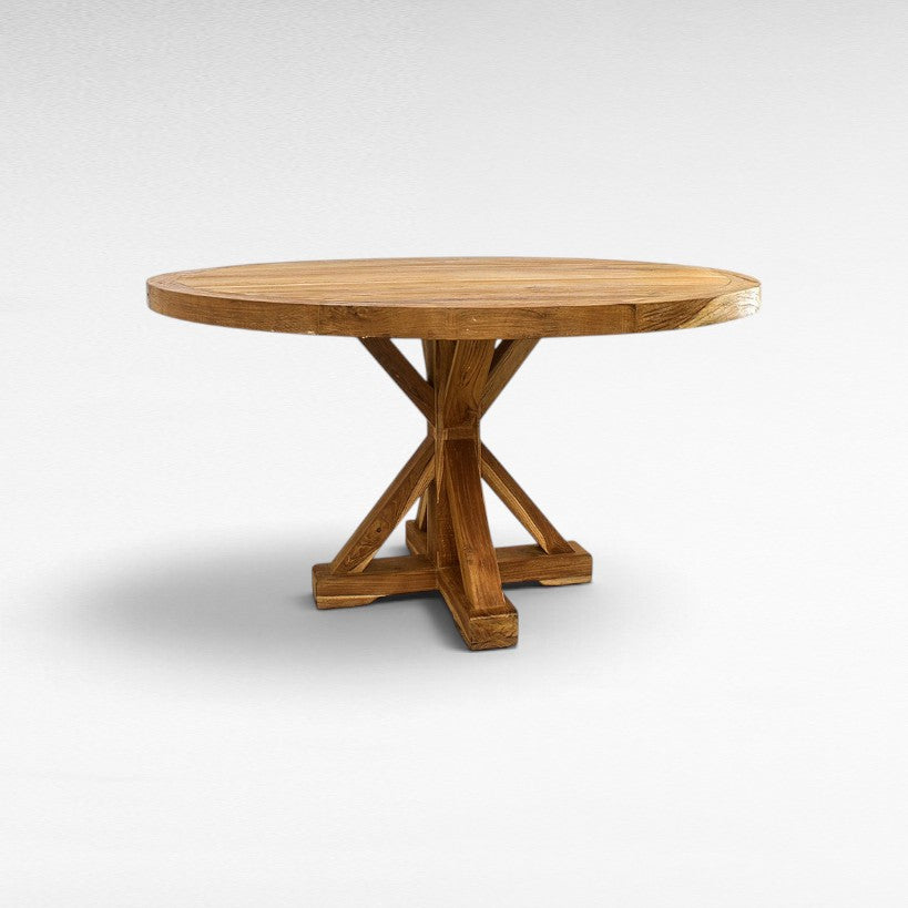 Chora Barefoot Luxury Living round wooden dining table with a sturdy cross-base design and natural grain finish.