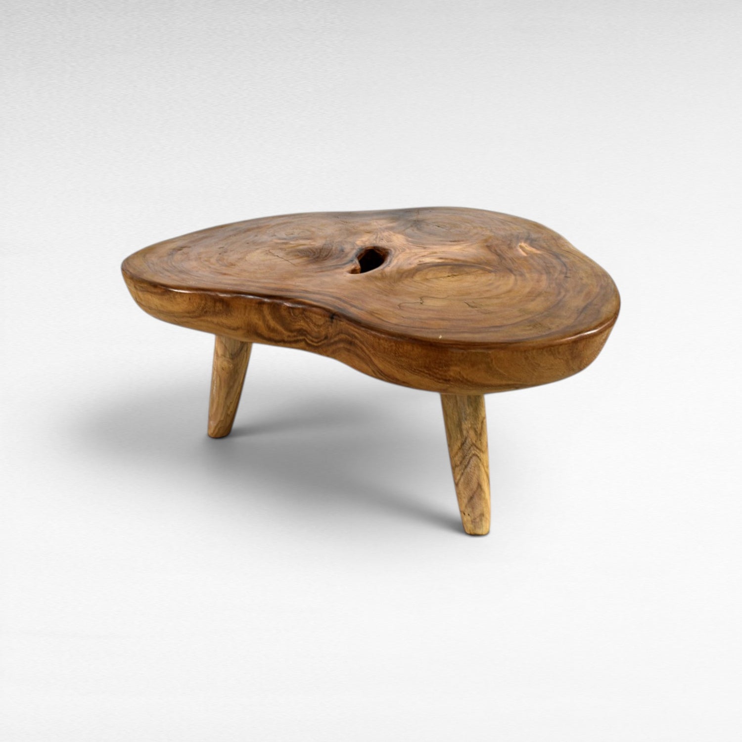 Chora Barefoot Luxury Living natural suar wood coffee table with organic grain and a central knot hole. Honey tones.
