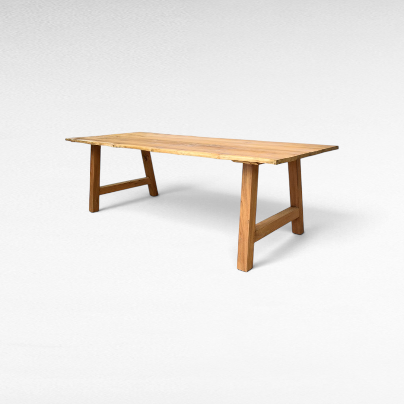 Chora Barefoot Luxury Living handcrafted suar wood dining table with natural live edges and sturdy trestle base.