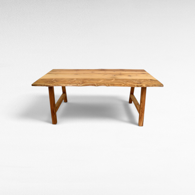 Chora Barefoot Luxury Living handcrafted suar wood dining table with a natural live edge and rich grain patterns.