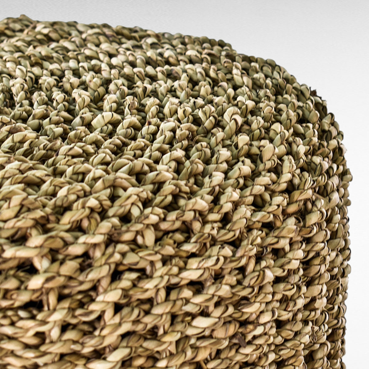 Close-up of a Chora Barefoot Luxury Living synthetic rattan stool in natural and white tones with a woven texture.