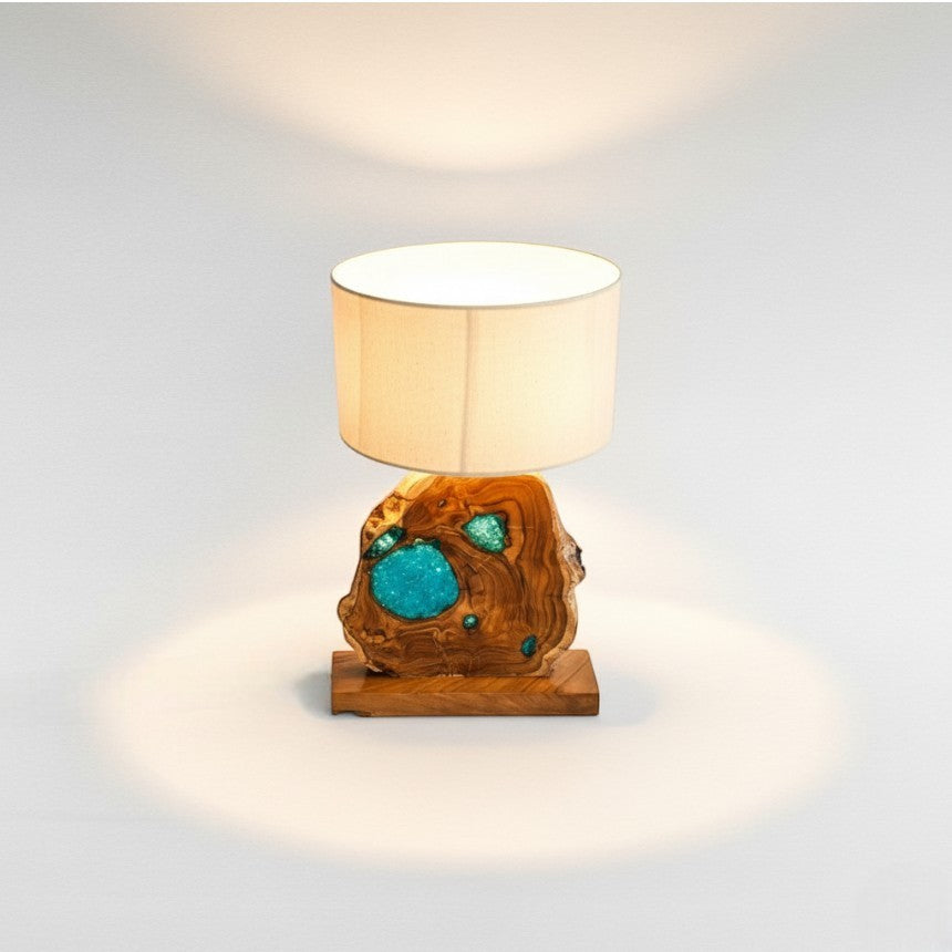 Chora Barefoot Luxury Living teak wood and blue resin table lamp with a natural wood base and beige drum shade.