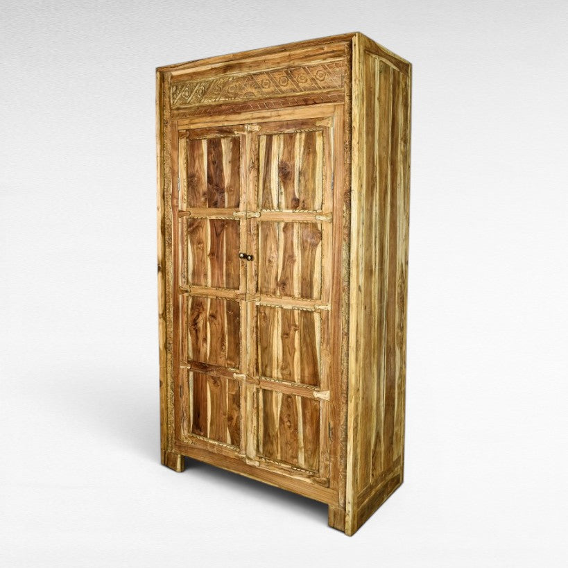 Chora Barefoot Luxury Living teak cabinet with carved details and two doors, natural wood finish.