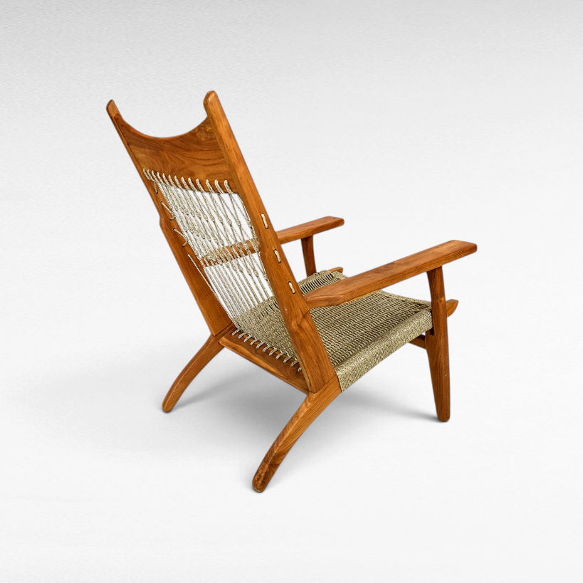 Chora Barefoot Luxury Living teak wood armchair with a woven synthetic raffia seat and decorative knotted backrest.