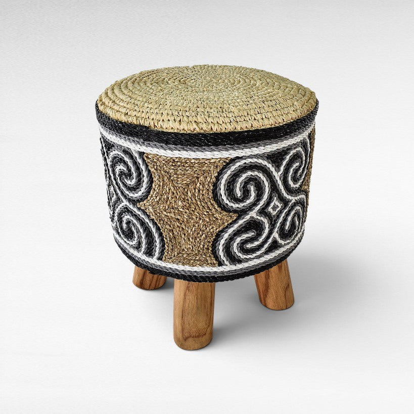 Chora Barefoot Luxury Living round stool with woven grass seat and black, white, and natural patterned rope sides.