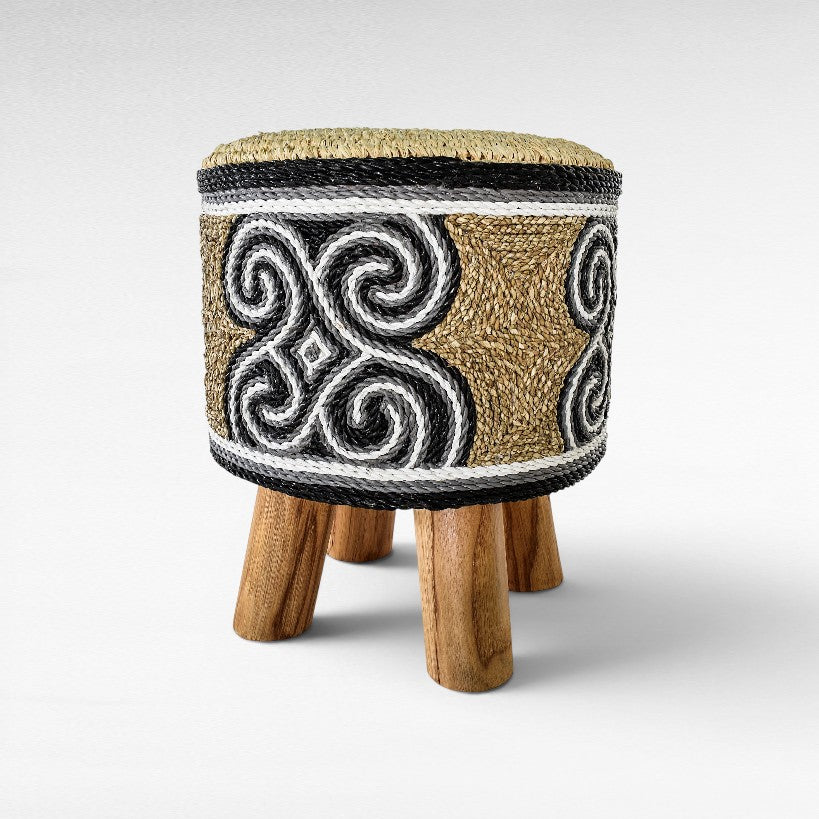 Chora Barefoot Luxury Living round wooden stool with a woven grass seat featuring black and white spiral patterns