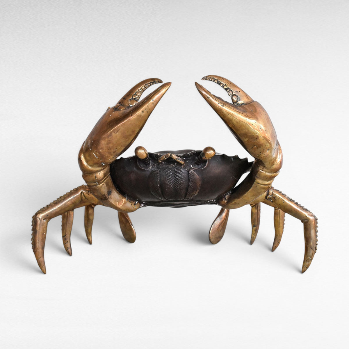 Chora Barefoot Luxury Living oversized bronze crab sculpture with polished brass claws and legs, black and gold finish.