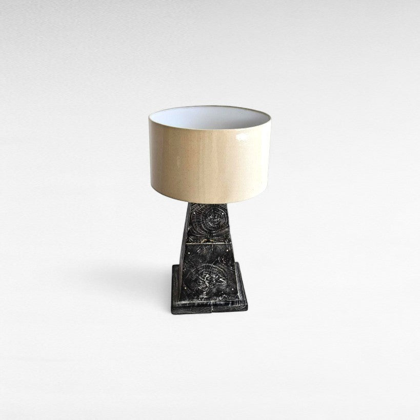 Chora Barefoot Luxury Living teak wood table lamp with a beige drum shade and a distressed black base featuring wood grain detail.