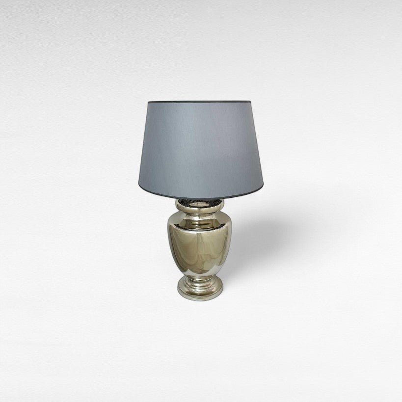 Chora Barefoot Luxury Living silver metal table lamp with a grey shade and urn-shaped base, modern design.