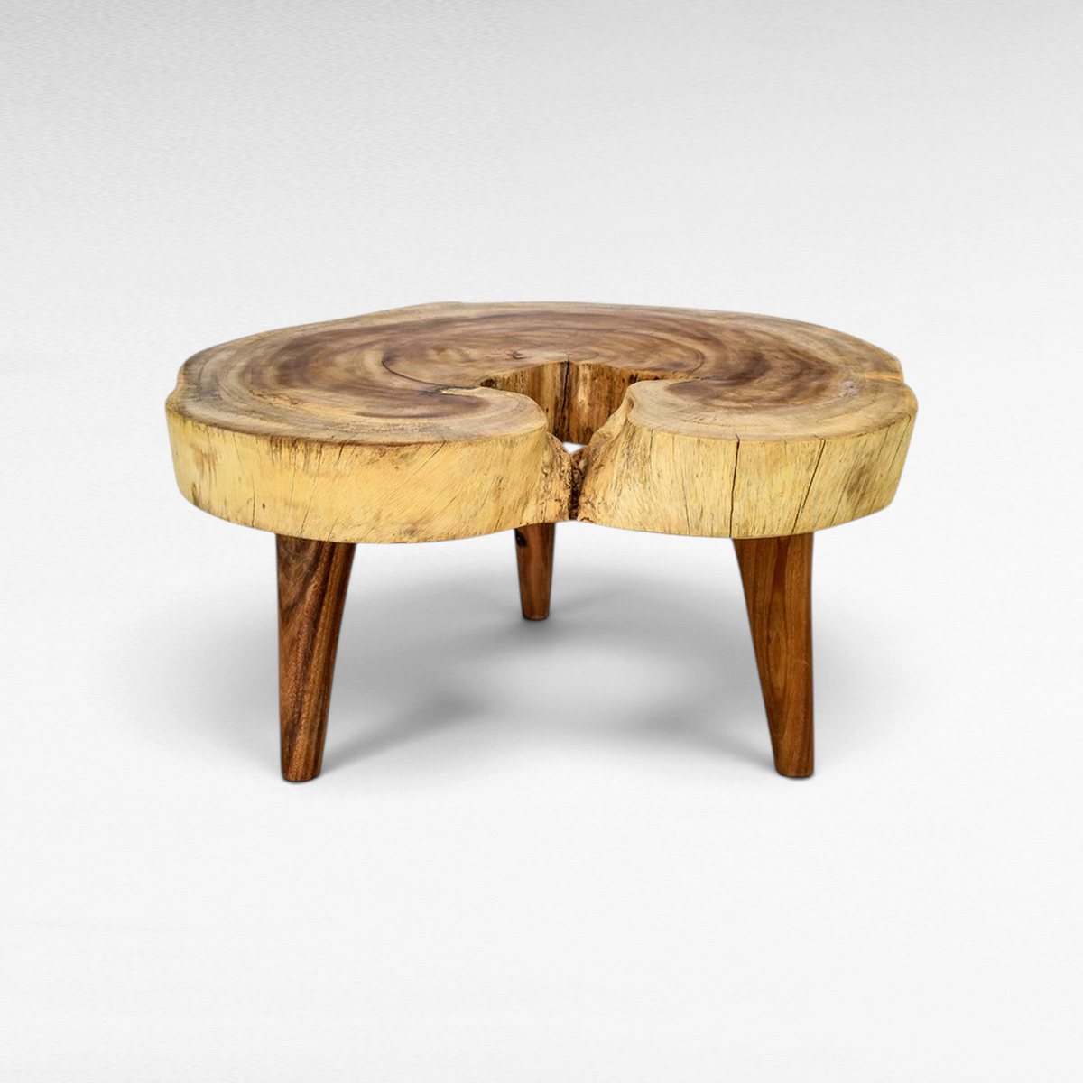 Chora Barefoot Luxury Living natural suar wood coffee table with a live edge round slab top and three sturdy legs.
