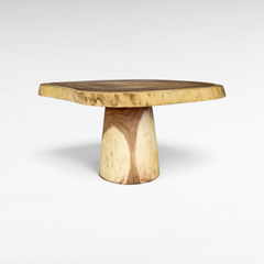 Chora Barefoot Luxury Living natural suar wood dining table with a live edge round top and a sturdy pedestal base.