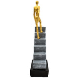 GOLD FIGURINE ON STAIRS