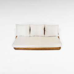 Chora Barefoot Luxury Living teak wood sofa with cream cushions and a warm honey-toned solid wood frame.