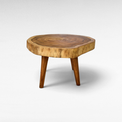 Chora Barefoot Luxury Living round natural wood coffee table with live edge and three tapered legs