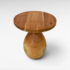 Chora Barefoot Luxury Living round suar wood coffee table with a natural grain finish and pedestal base
