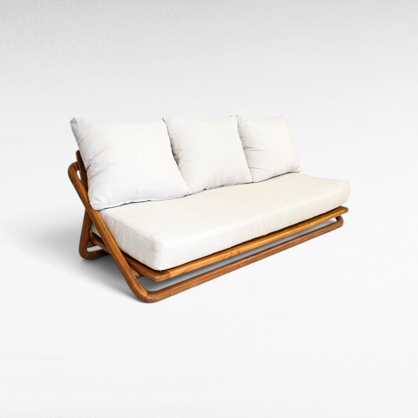 Chora Barefoot Luxury Living handcrafted teak wood sofa with white cushions and a warm honey-toned solid wood frame.