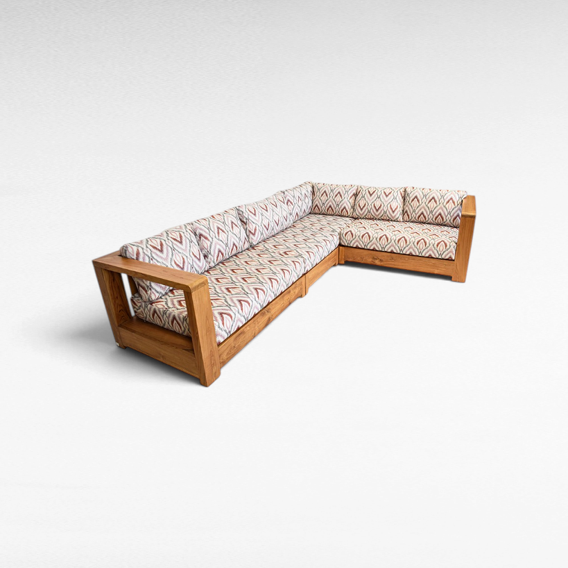 Chora Barefoot Luxury Living teak wood L-shaped sectional sofa with patterned cushions in a natural wood finish