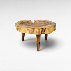 Chora Barefoot Luxury Living suar wood coffee table with a natural live edge round top and three sturdy wooden legs.