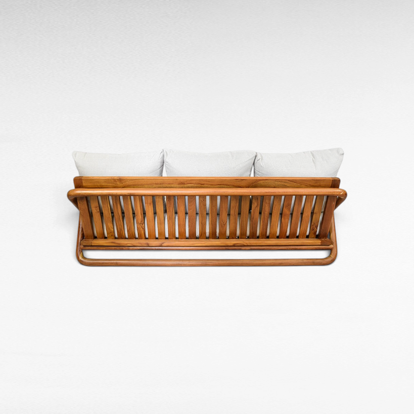Back view of a Chora Barefoot Luxury Living teak wood sofa with slatted frame and light grey cushions