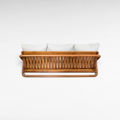 Back view of a Chora Barefoot Luxury Living teak wood sofa with slatted frame and light grey cushions