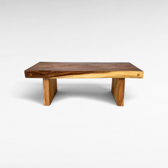 Chora Barefoot Luxury Living suar wood coffee table with a natural live edge finish and sturdy block legs.