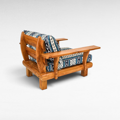 Chora Barefoot Luxury Living teak wood sofa chair with blue and white patterned cushions in a rustic design