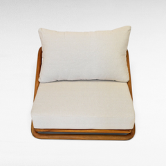 Chora Barefoot Luxury Living teak wood sofa chair with plush beige cushions and a natural honey-toned wood frame.
