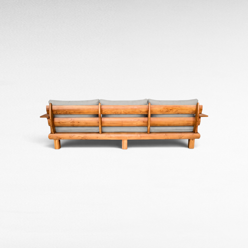Chora Barefoot Luxury Living teak wood sofa back view with grey cushions, showcasing natural wood grain and slats.