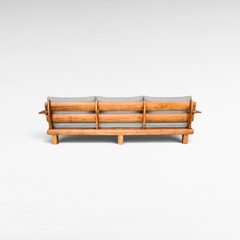 Chora Barefoot Luxury Living teak wood sofa back view with grey cushions, showcasing natural wood grain and slats.
