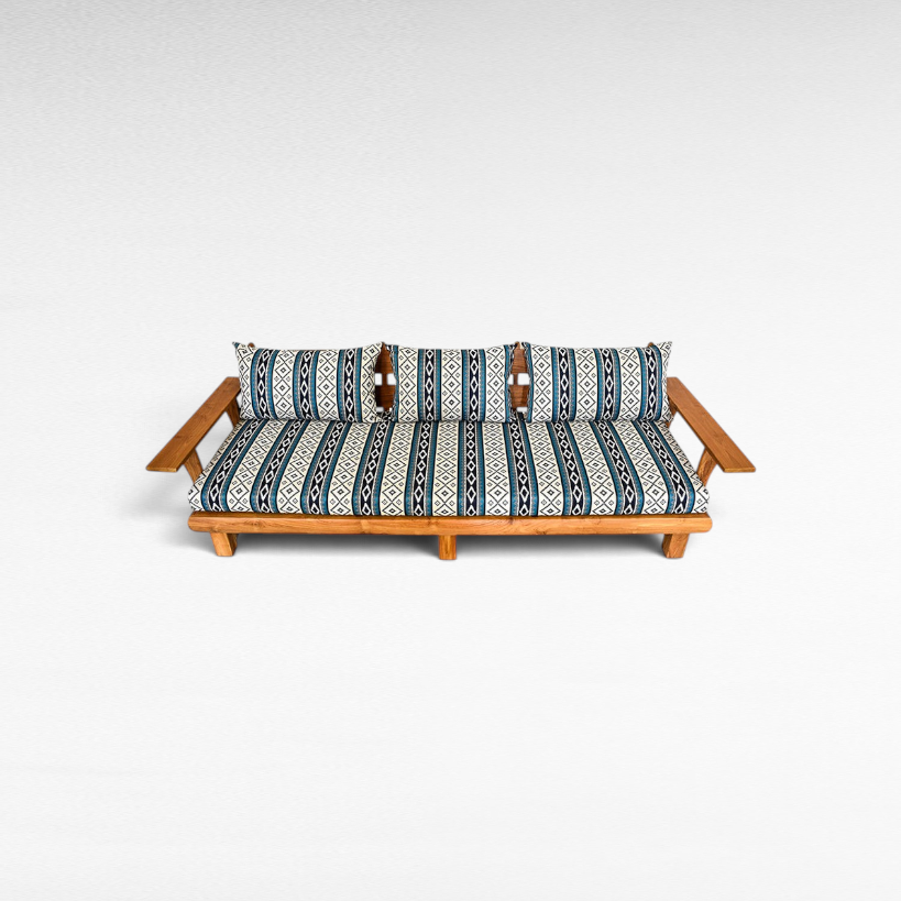 Chora Barefoot Luxury Living teak wood sofa with blue and white patterned cushions on a white background