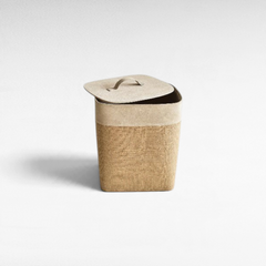 Chora Barefoot Luxury Living beige jute and suede leather storage basket with a matching lid on a white background