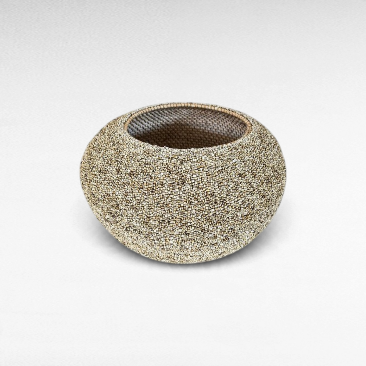 Chora Barefoot Luxury Living handcrafted rattan basket featuring an intricate, textured beaded exterior finish.