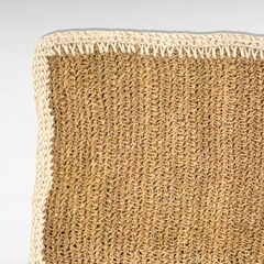 Chora Barefoot Luxury Living synthetic grass carpet with a textured natural brown weave and a white braided border.