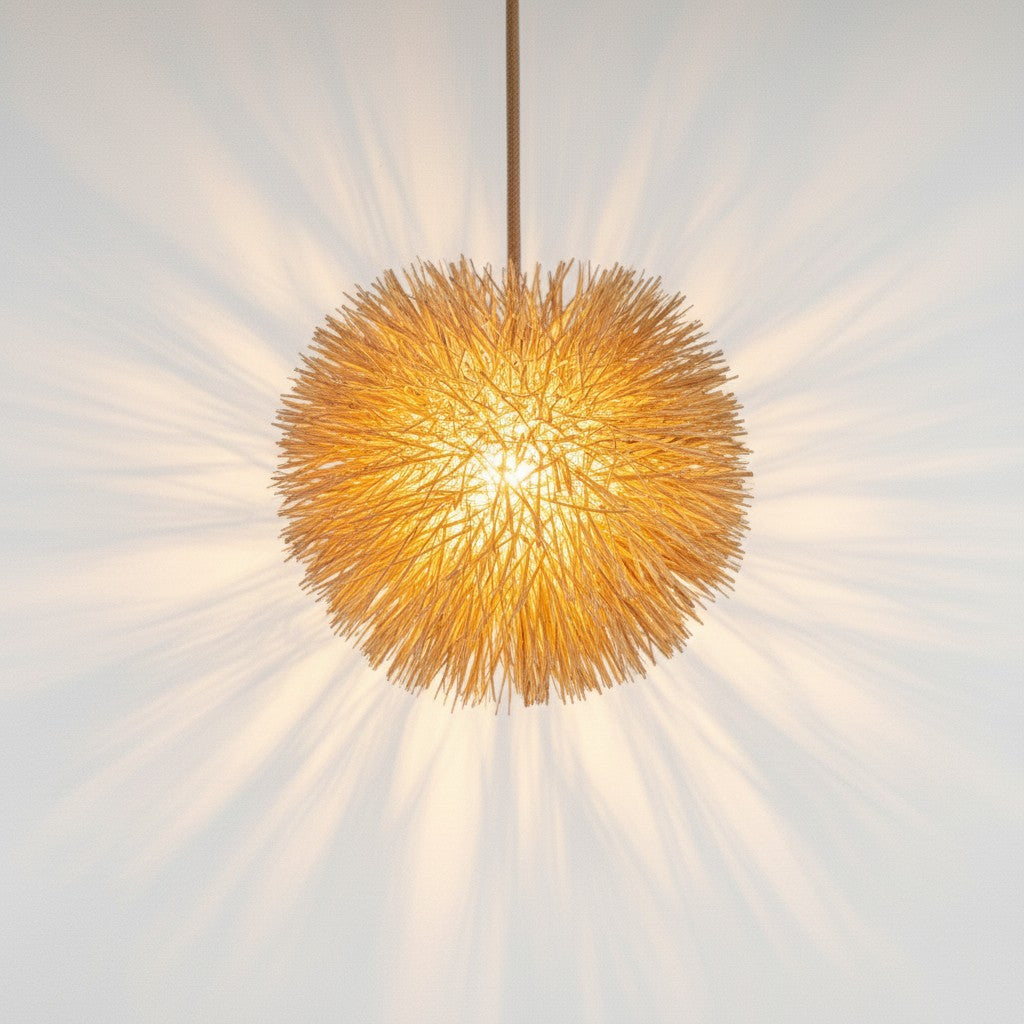 Chora Barefoot Luxury Living bamboo sea urchin pendant light emitting a warm, radiant glow against a white wall.