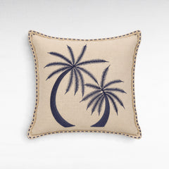 Chora Barefoot Luxury Living square beige linen cushion with navy blue embroidered palm tree design and stitched edge