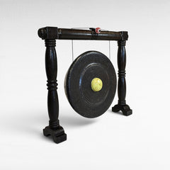 Chora Barefoot Luxury Living black ceremonial gong decoration with a yellow center and wooden stand.