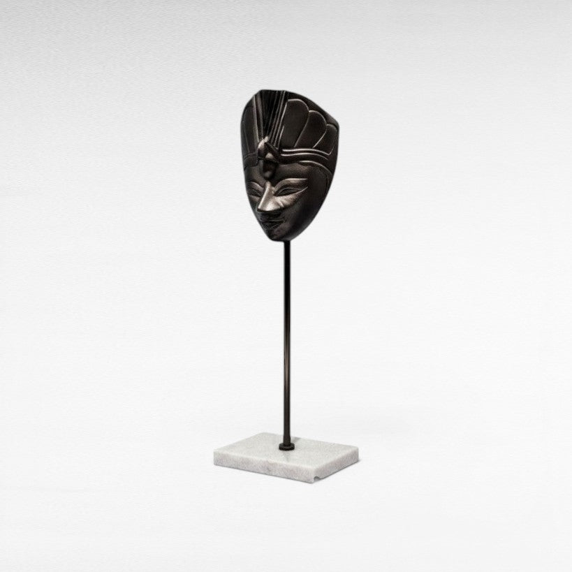 Chora Barefoot Luxury Living black metal figurine mask on a marble base, featuring intricate details and a regal headdress.