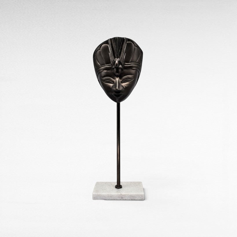 Chora Barefoot Luxury Living black metal decorative mask on a marble base stand, featuring intricate Egyptian-inspired design.