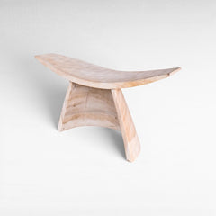 Chora Barefoot Luxury Living bleached suar wood stool with a curved seat and minimalist sculptural design.