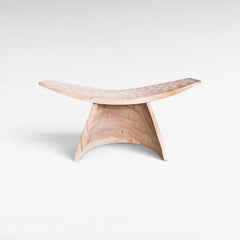 Chora Barefoot Luxury Living bleached suar wood stool with a curved seat and minimalist sculptural design.