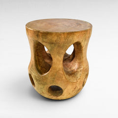 Chora Barefoot Luxury Living carved wood side table with curves and holes, natural wood finish.